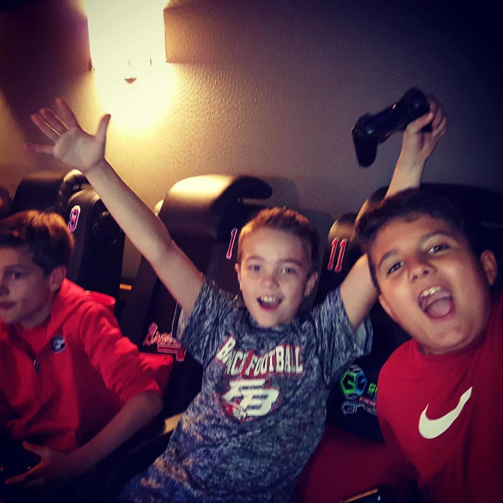 a game bus video party that has 3 boys cheering