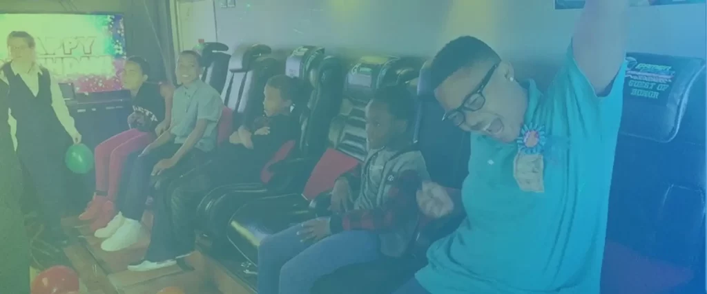 Young man raising hand in victory, from inside the Game Truck Atlanta Celebration Trailer. Proving that we are the best gaming truck near me