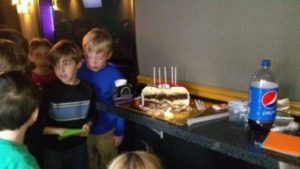 Kids gathered around table full of food inside our game bus rental